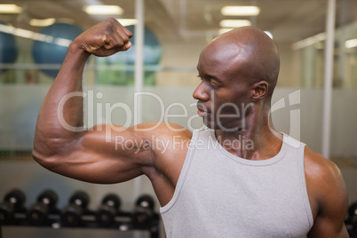 Muscular man flexing muscles in gym