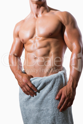 Mid section of a shirtless muscular man in white towel