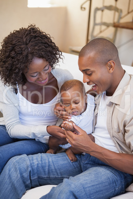 Happy parents spending time with baby on the couch