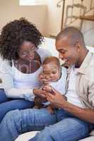 Happy parents spending time with baby on the couch