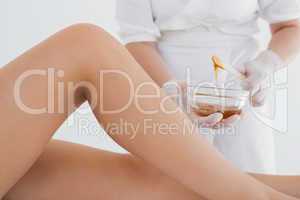 Therapist waxing womans leg at spa center