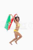 Athletic girl in yellow bikini holding portugal flag