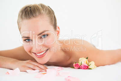 Pretty blonde lying on massage table with rose petals