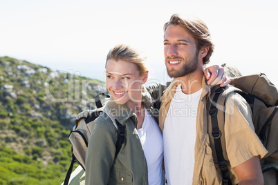 Attractive hiking couple hugging on mountain trail