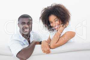Couple sitting on couch together smiling at camera