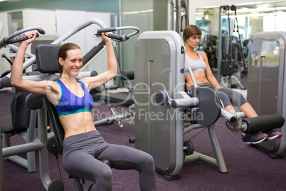 Healthy brunette using weights machine for arms