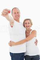 Mature couple smiling at camera with new house key