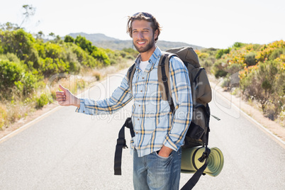 Attractive man hitch hiking on rural road