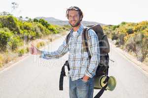 Attractive man hitch hiking on rural road