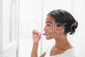 Pretty woman brushing her teeth