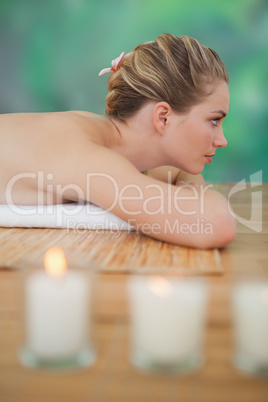 Peaceful blonde lying on bamboo mat