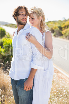 Attractive couple embracing by the road