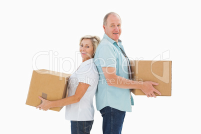 Happy older couple holding moving boxes