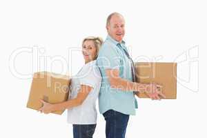 Happy older couple holding moving boxes