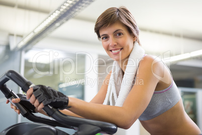 Fit smiling woman working out on the exercise bike