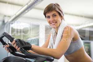 Fit smiling woman working out on the exercise bike