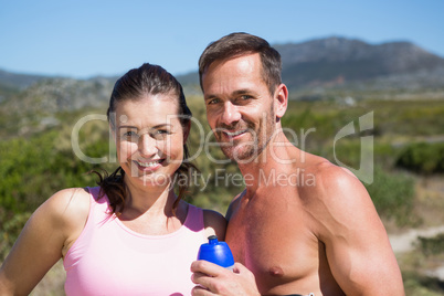 Active couple smiling at camera in the countryside