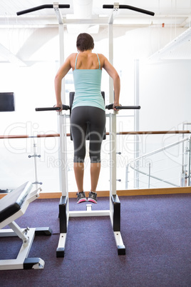 Fit brunette supporting her weight on bars Fit brunette supporting her weight on bars