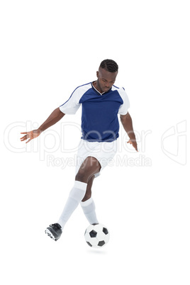 Football player in blue jersey controlling ball