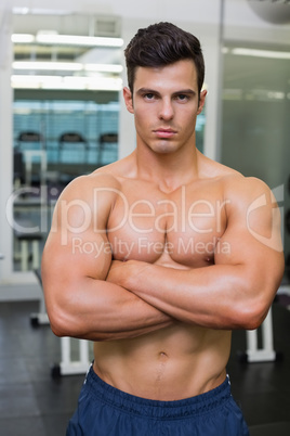 Serious young muscular man in gym