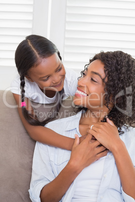 Pretty mother sitting on the couch with her daughter Pretty mother sitting on the couch with her daughter