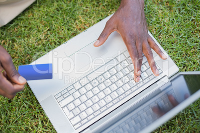 Man relaxing in his garden using laptop to shop