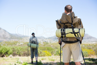 Happy hiking couple walking on mountain trail