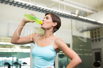 Fit brunette drinking energy drink