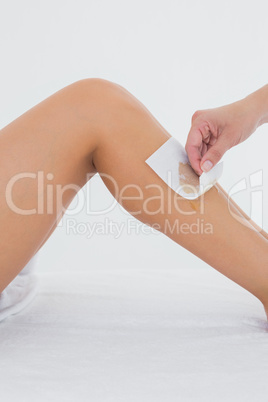 Therapist waxing womans leg at spa center