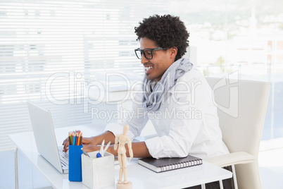 Happy hipster businessman working at his desk