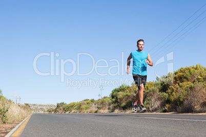 Athletic man jogging on the open road