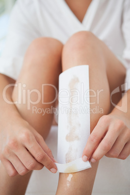 Woman waxing her legs herself