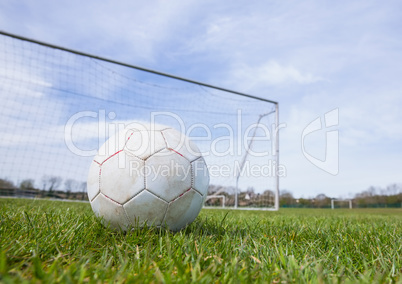 Football on an empty pitch in front of goal