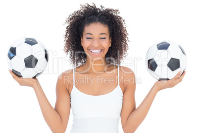 Pretty girl with afro hairstyle smiling at camera holding footba