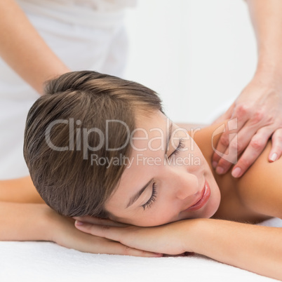 Attractive woman receiving shoulder massage at spa center