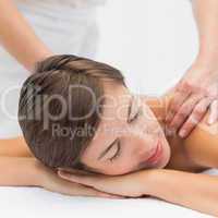 Attractive woman receiving shoulder massage at spa center