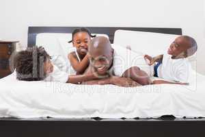 Happy family laughing together in bed