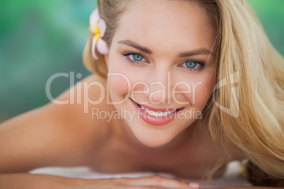 Peaceful blonde lying on towel smiling at camera