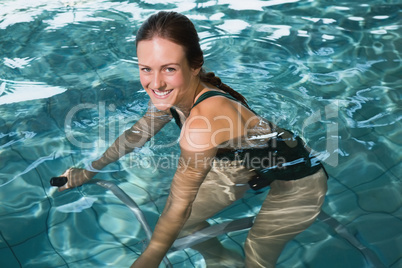 Fit brunette using underwater exercise bike