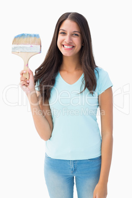 Happy young brunette holding paintbrush