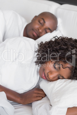 Happy couple lying in bed together sleeping