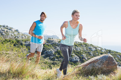 Fit couple jogging through countryside