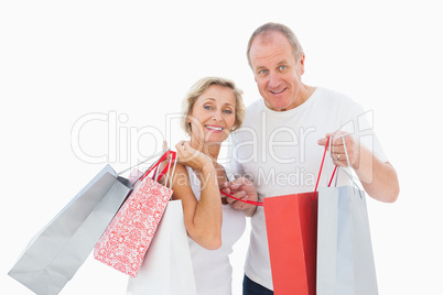 Smiling mature couple holding shopping bags
