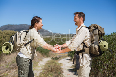 Hiking couple putting hands together on country trail