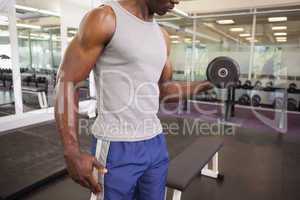 Muscular man exercising with dumbbell in gym