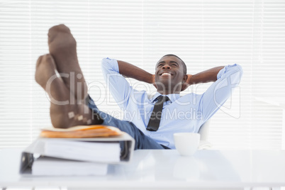 Relaxed businessman sitting in his chair with feet up