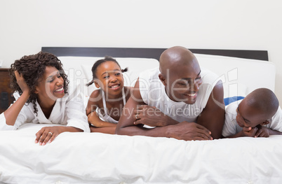 Happy family laughing together in bed