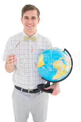 Geeky hipster holding a globe smiling at camera