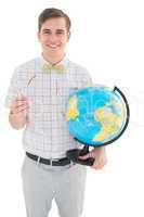 Geeky hipster holding a globe smiling at camera