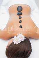 Beautiful woman receiving stone massage at spa center